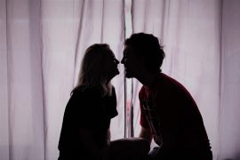 Jeune couple d'amoureux qui s'embrassent dans la pénombre