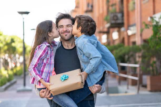 Deux enfants qui offrent un cadeau à leur papa pour la fête des pères