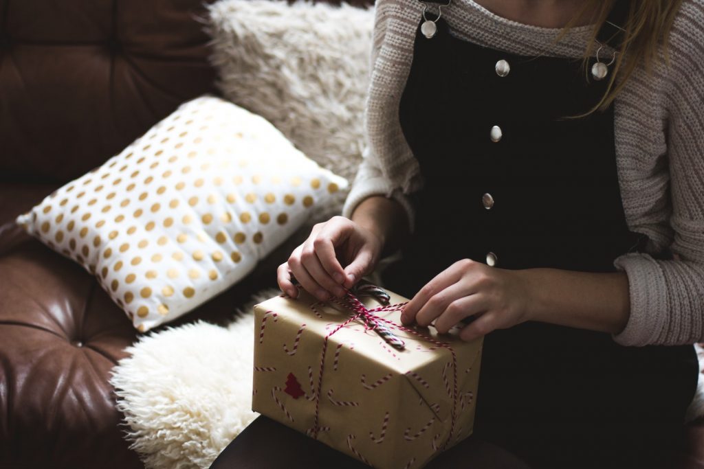 Jeune femme qui ouvre son cadeau de Noël